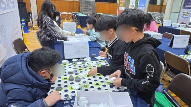 학생들이 그래비트랙스 보드 앞에서 모둠별로 협업하는 장면