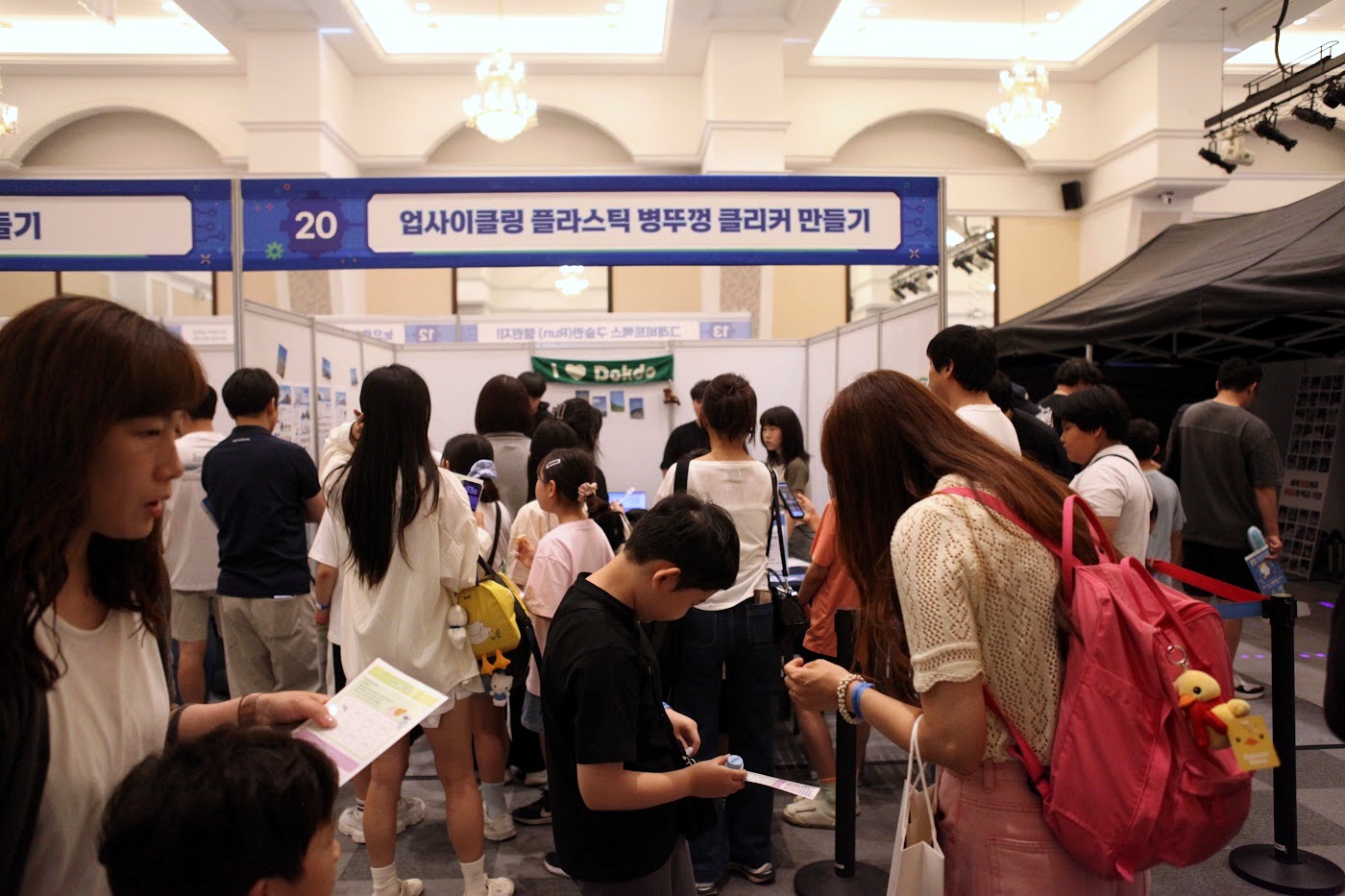 행사 현장에서 부스 체험을 기록하는 장면